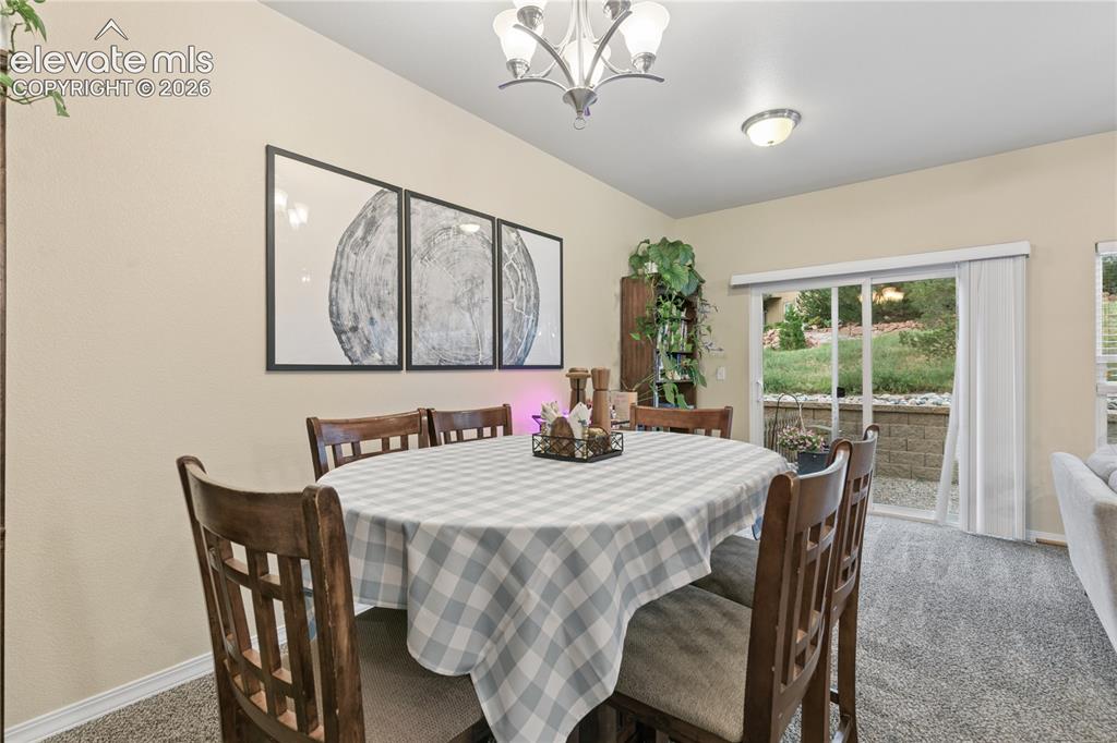 Image 8 of 28: Dining area featuring neutral wall tones, carpet flooring, a sliding glass
