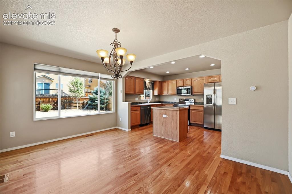 Image 11 of 47: Open concept living space featuring wood- flooring, dining space, and an ar