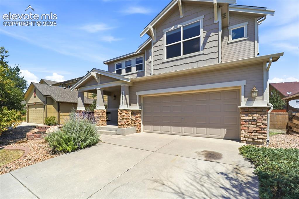 Image 2 of 47: Craftsman-style home featuring a two-car garage, stone and siding exterior,