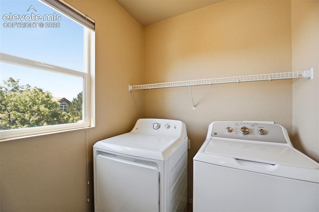 Image 20 of 47: Dedicated laundry area featuring a white wire shelving unit, a large window