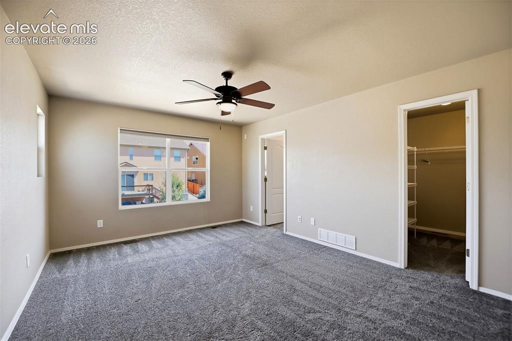 Image 21 of 47: Spacious room featuring neutral-toned walls, plush grey carpeting, a multi-