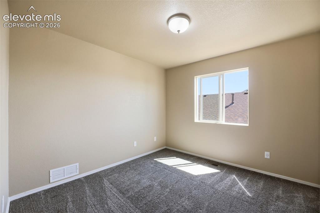 Image 28 of 47: Neutral tone walls with an individual window, gray carpet flooring, and whi