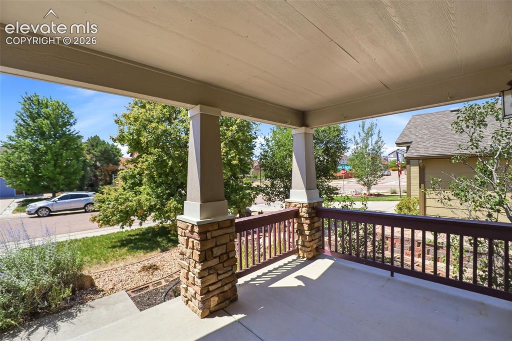 Image 3 of 47: Covered frontporch featuring stone-wrapped pillars, a painted wood railing,