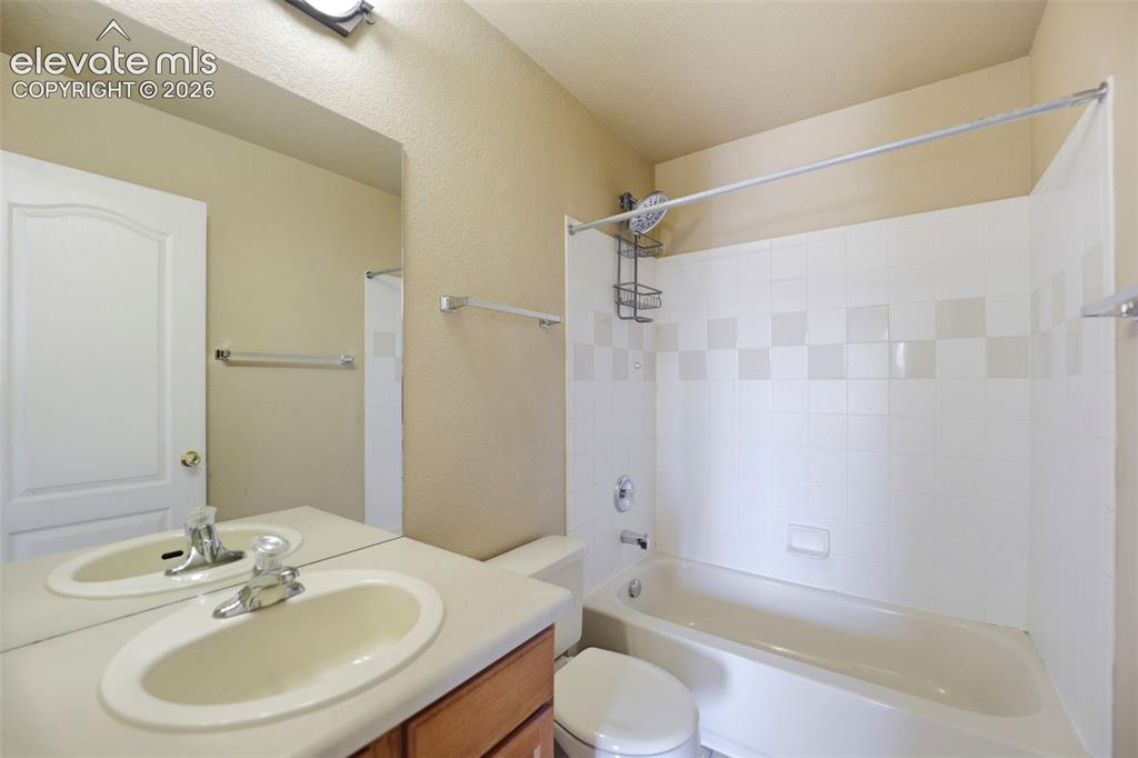 Image 30 of 47: Bathroom featuring a white vanity with an integrated sink, a large wall-mou