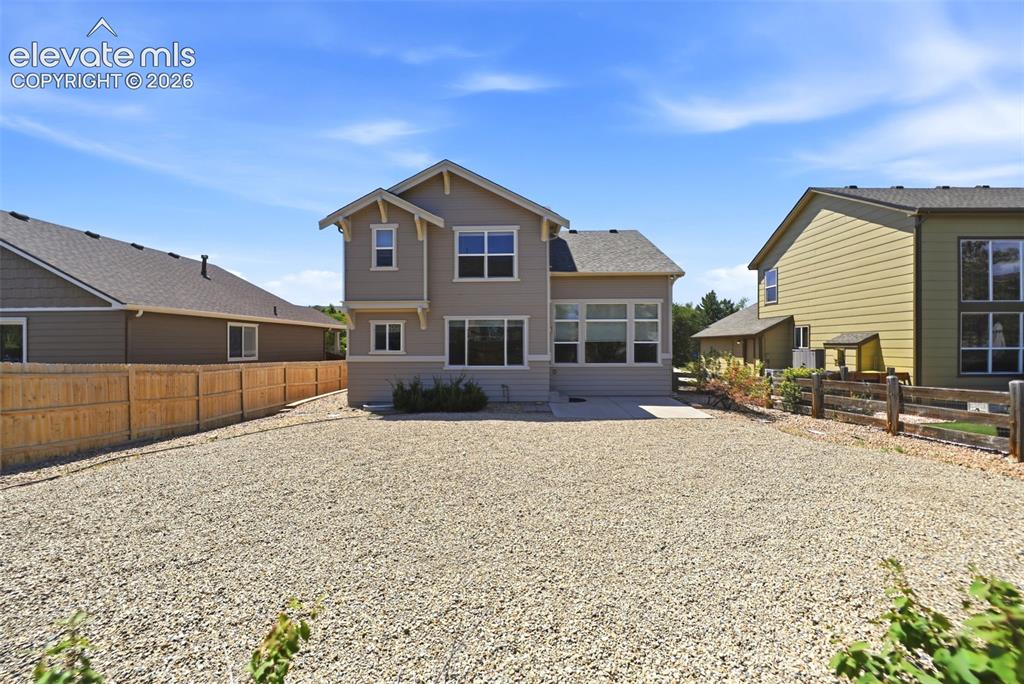 Image 33 of 47: Rear exterior of a two-story residence featuring a light-toned facade and m