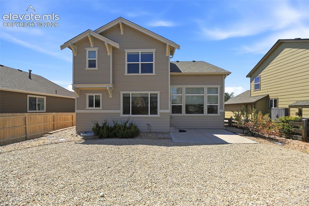 Image 34 of 47: Rear exterior showcasing a neutral-toned siding, multiple windows across tw