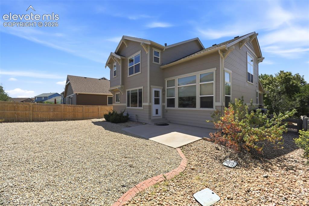 Image 35 of 47: Rear exterior featuring neutral siding and multiple windows