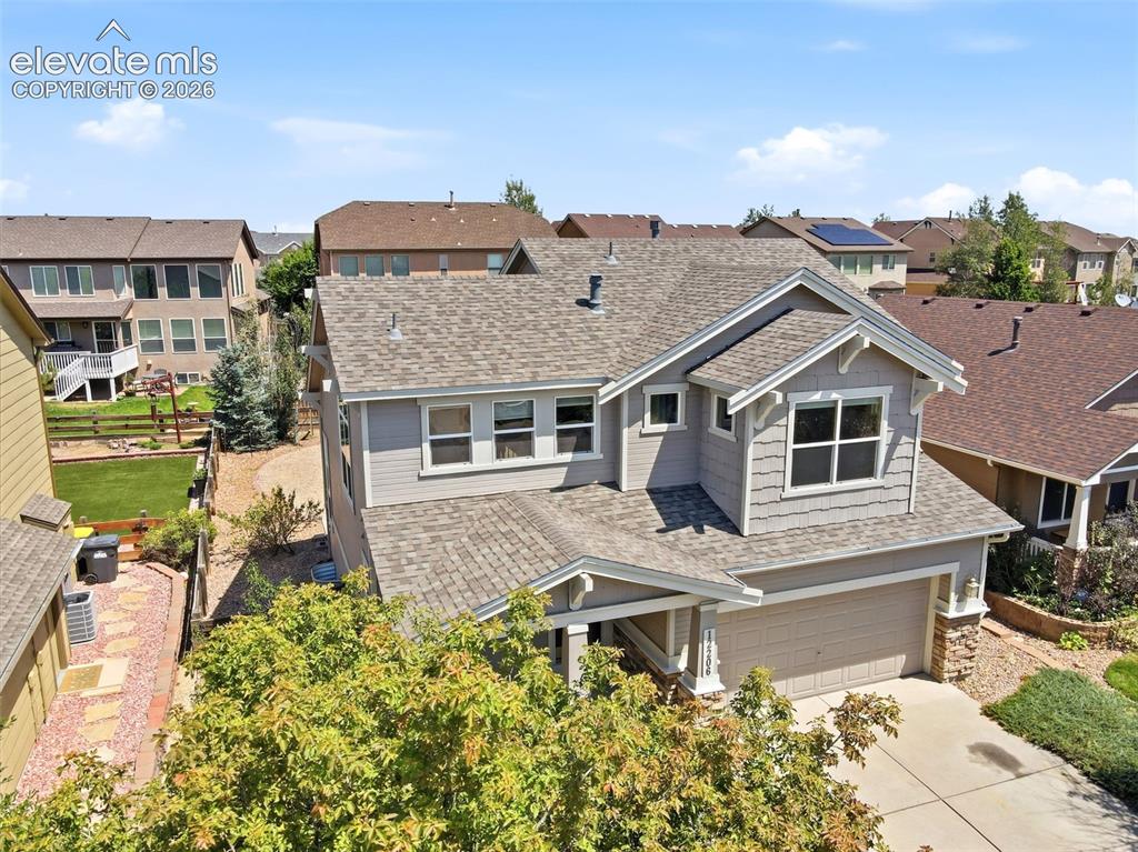 Image 39 of 47: Two-story residence featuring a gray exterior siding and a multi-pitch shin