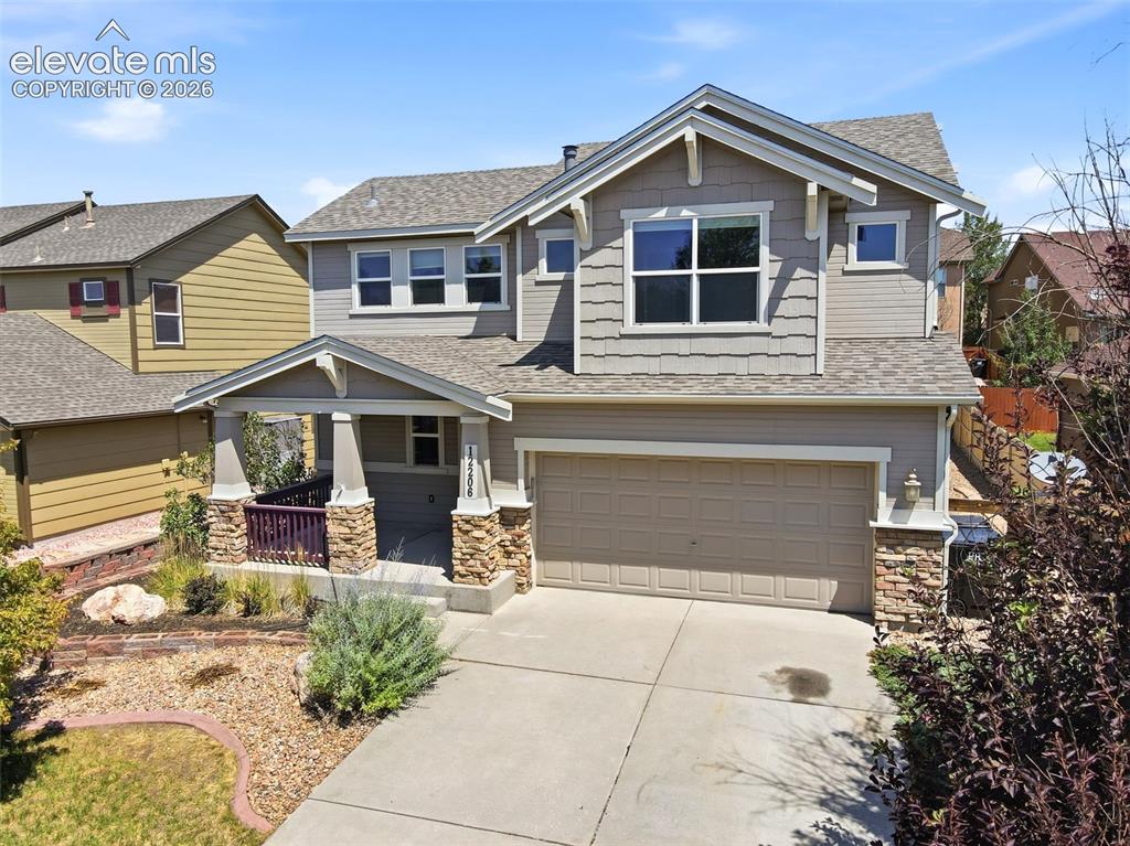 Image 40 of 47: Craftsman-style exterior featuring a covered front porch with stone-wrapped