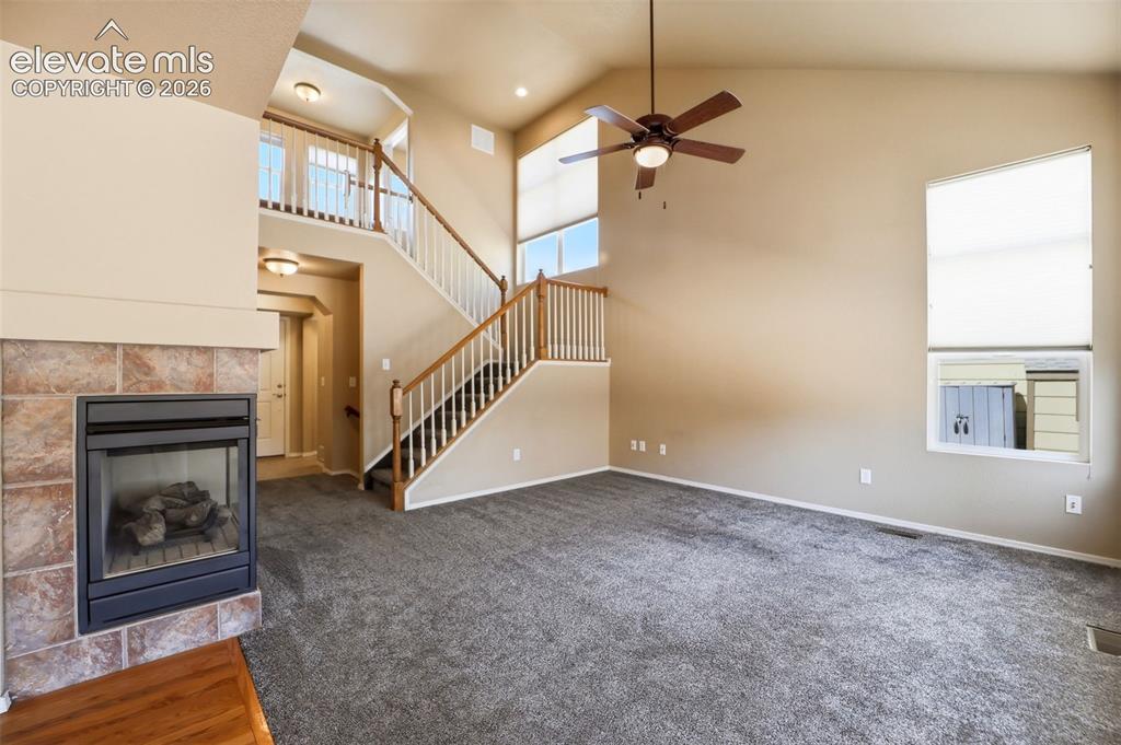 Image 7 of 47: Living area featuring a corner gas fireplace with stone tile surround, a du