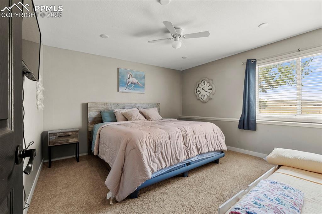 Image 23 of 35: Carpeted bedroom featuring ceiling fan and baseboards