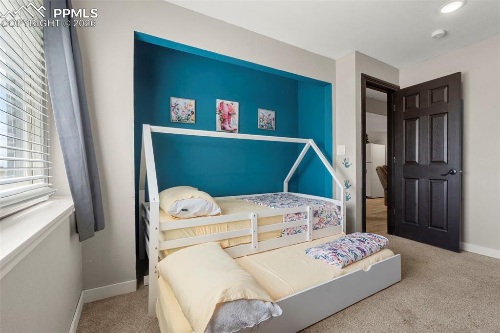 Image 24 of 35: Bedroom featuring light colored carpet and freestanding refrigerator