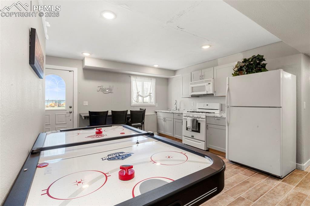 Image 26 of 35: Game room with wood finish floors and recessed lighting