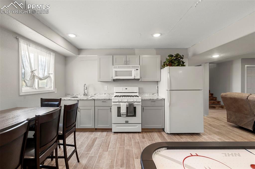 Image 27 of 35: Kitchen featuring white appliances, wood tiled floors, open floor plan, rec