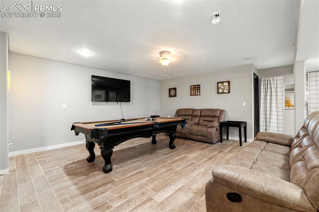Image 28 of 35: Playroom with billiards table and wood finish floors