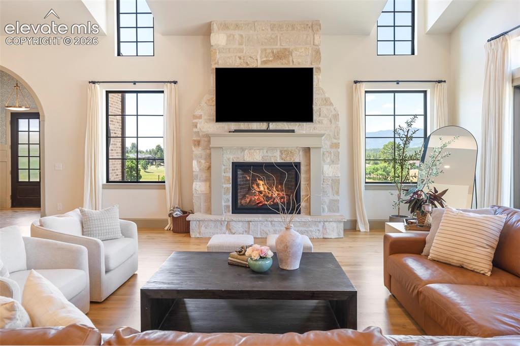 Image 14 of 49: Natural stone fireplace, adorned with classic English millwork, anchors the