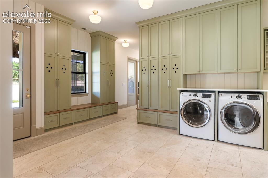 Image 16 of 49: Luxurious household workspace, the expansive laundry room features extensiv
