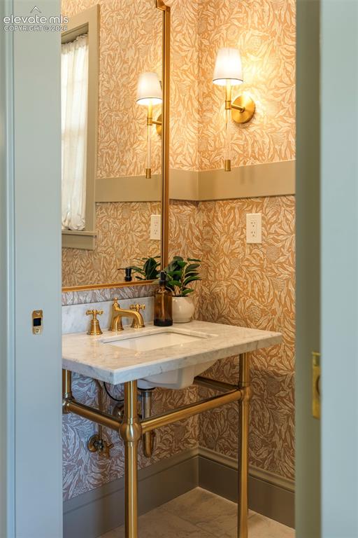 Image 19 of 49: Custom wall paper, designer finishes in the guest Powder Room just off the