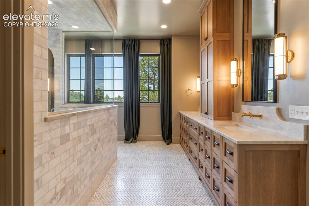 Image 22 of 49: Private Spa Sanctuary, the expansive primary bathroom is bathed in natural