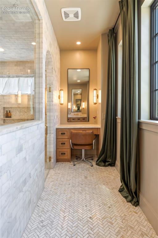 Image 26 of 49: Hidden countertop storage, warm quartzite countertops, and elegant wall mou