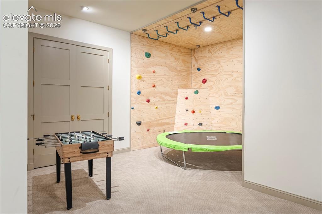 Image 33 of 49: Space for a game table, rock climbing wall, custom under stair playhouse bl