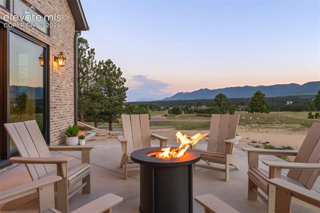 Image 4 of 49: Outdoor fire pit with breathtaking mountain views, perfect for relaxing eve