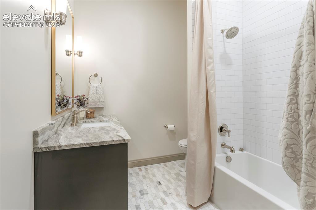 Image 41 of 49: Marble flooring, marble countertops, and tiled tub.