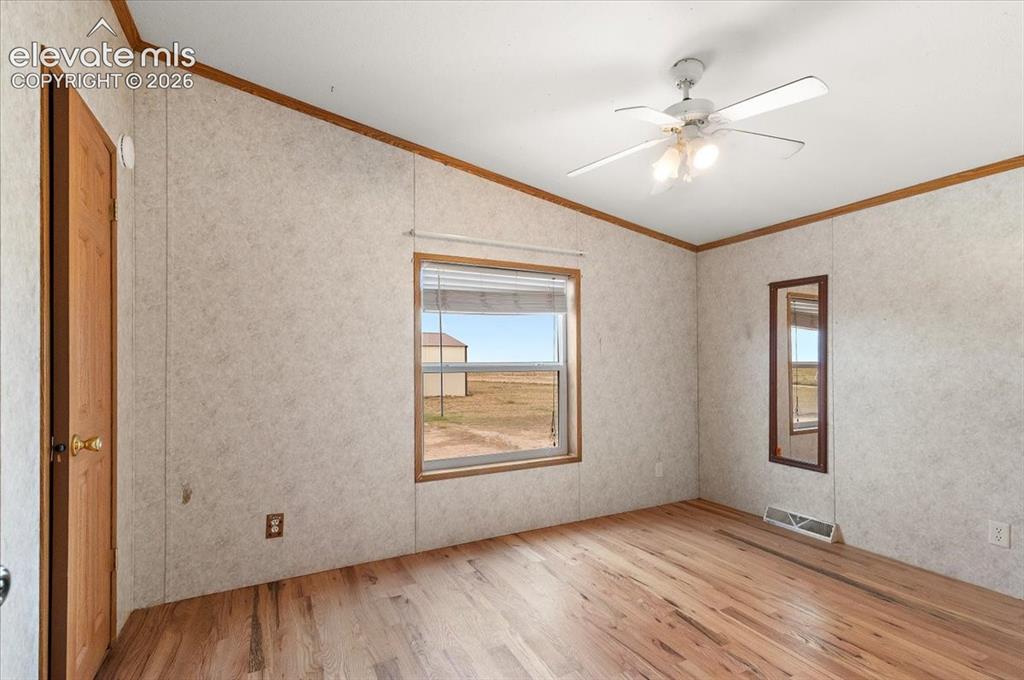 Image 14 of 23: Wood-finish flooring, ceiling fan with integrated lighting, natural light w