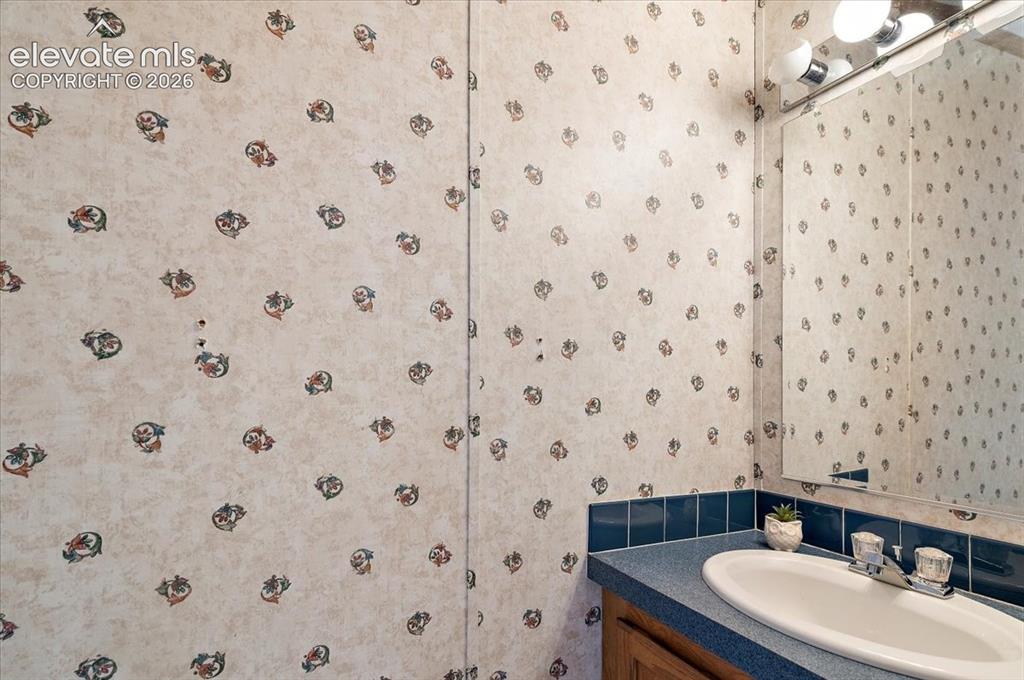 Image 15 of 23: Recessed sink with dual-handle faucet, blue countertop, and blue tile backs