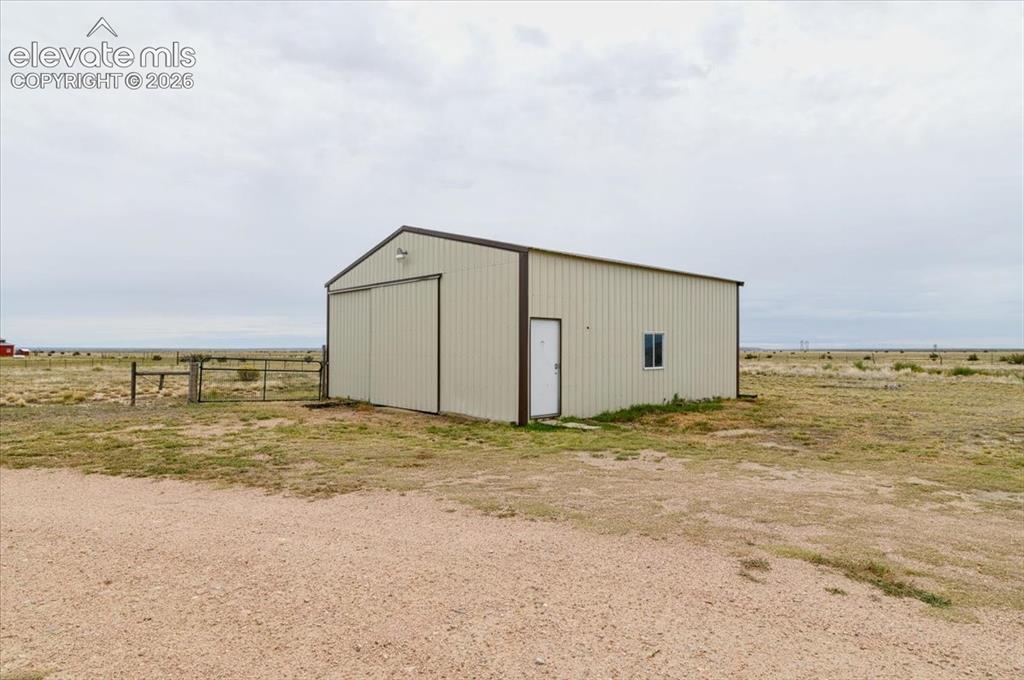Image 16 of 23: Metal-sided structure featuring a gable roof, two entry doors, and a single