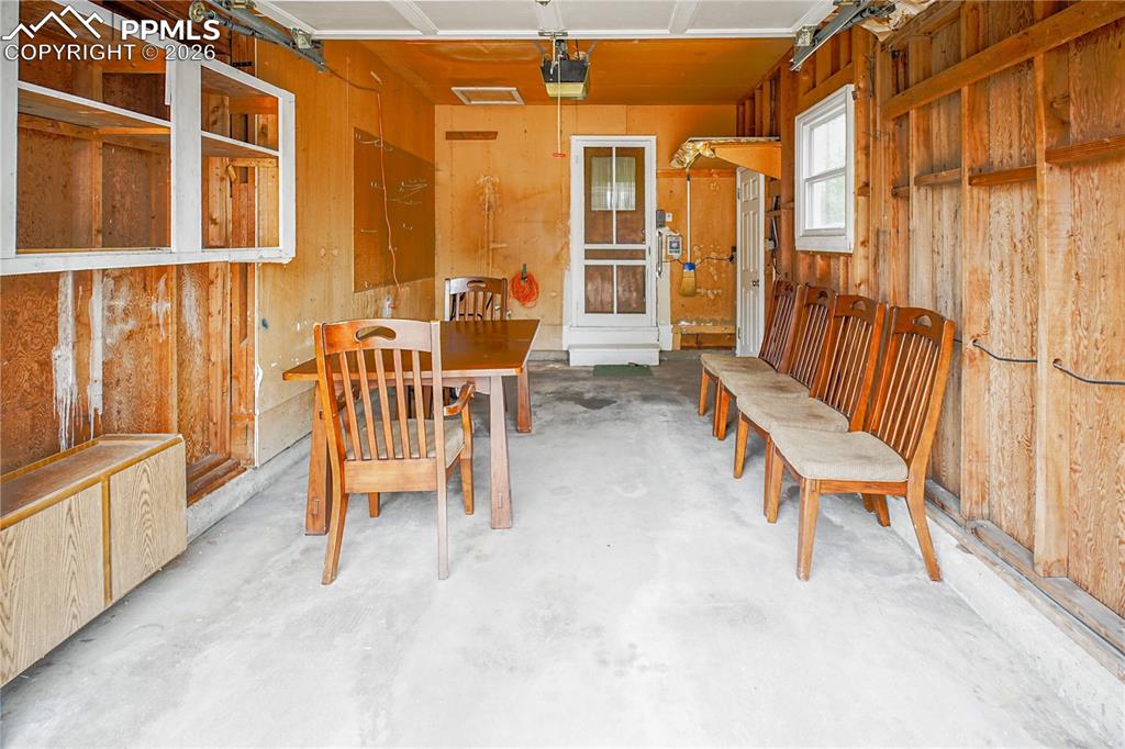 Image 27 of 28: A single car garage with screened door to the main house and access door to