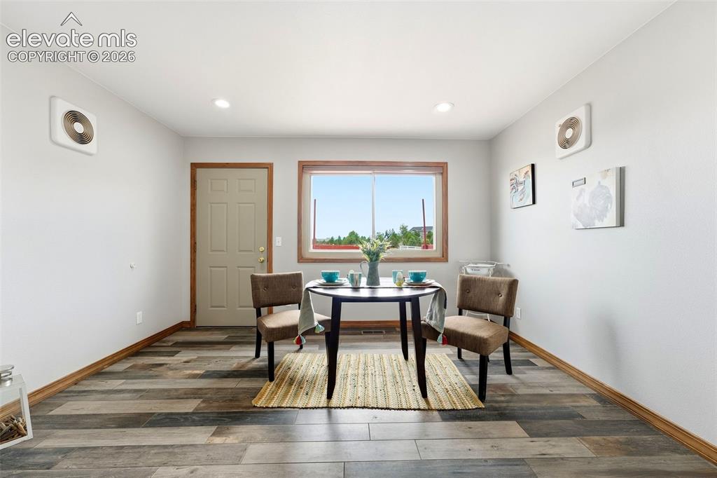Image 10 of 50: Recessed lighting, wood-finish flooring, wood trim, white walls, and a mult