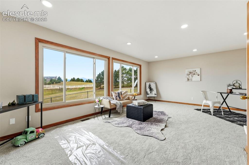 Image 15 of 50: Expansive room featuring multiple windows with wood trim, recessed lighting