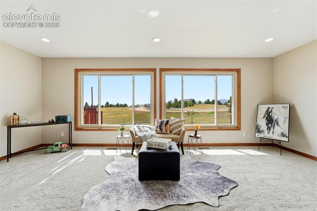 Image 16 of 50: Recessed lighting, light-toned walls, and wood-trimmed windows
