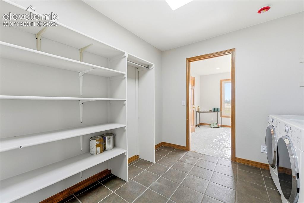 Image 18 of 50: Built-in shelving, tile flooring, wood-finish trim, and skylight