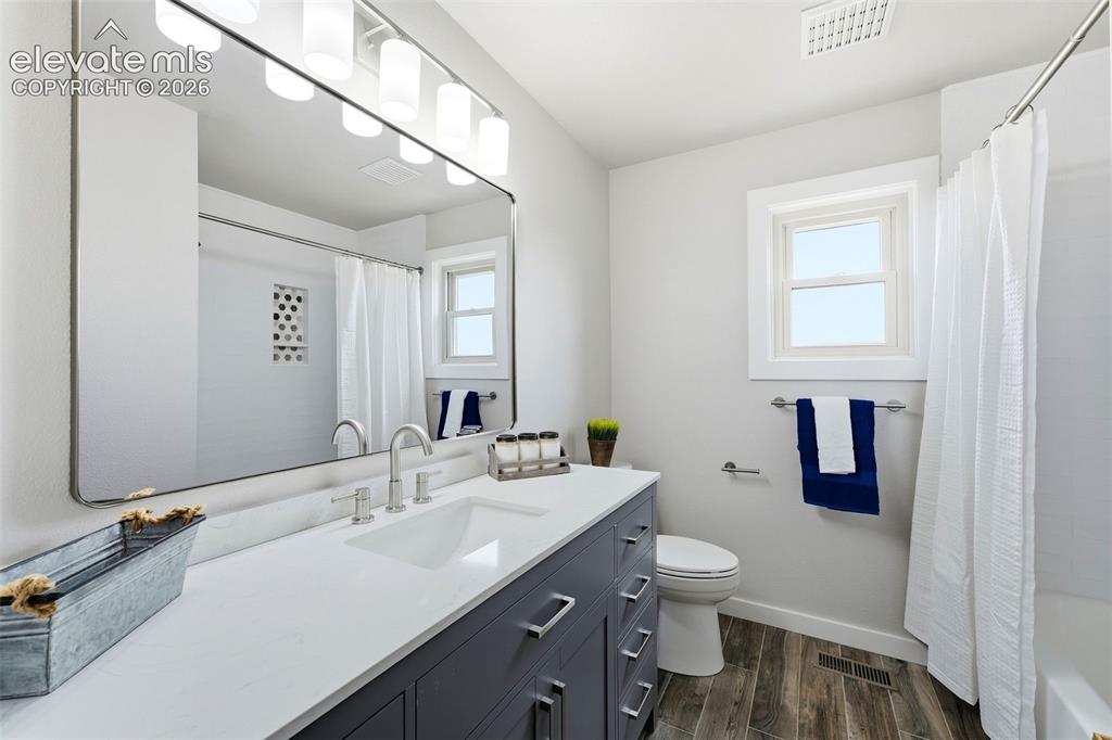 Image 20 of 50: White vanity with a rectangular sink, wall-mounted mirror, brushed nickel f