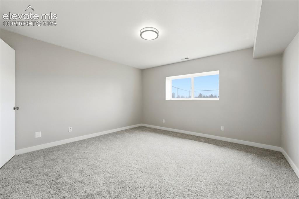 Image 24 of 50: Wall-to-wall carpeting in a neutral tone, flush-mount ceiling light, white