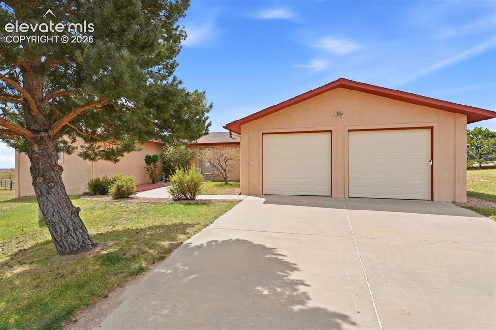 Image 3 of 50: Stucco exterior with an oversized two-car garage, concrete driveway, and ma