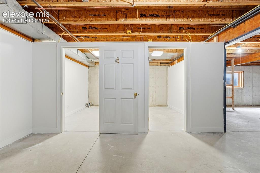Image 33 of 50: Open unfinished basement offering concrete flooring, exposed wood beams, an