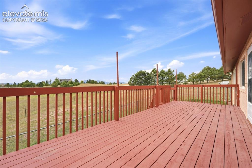 Image 35 of 50: Expansive outdoor deck with wood-finish flooring and railing