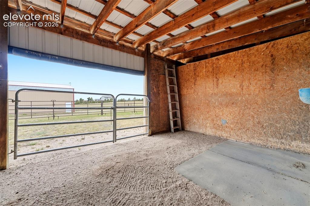 Image 39 of 50: Open-air structure with exposed wood beam ceiling, corrugated metal roofing