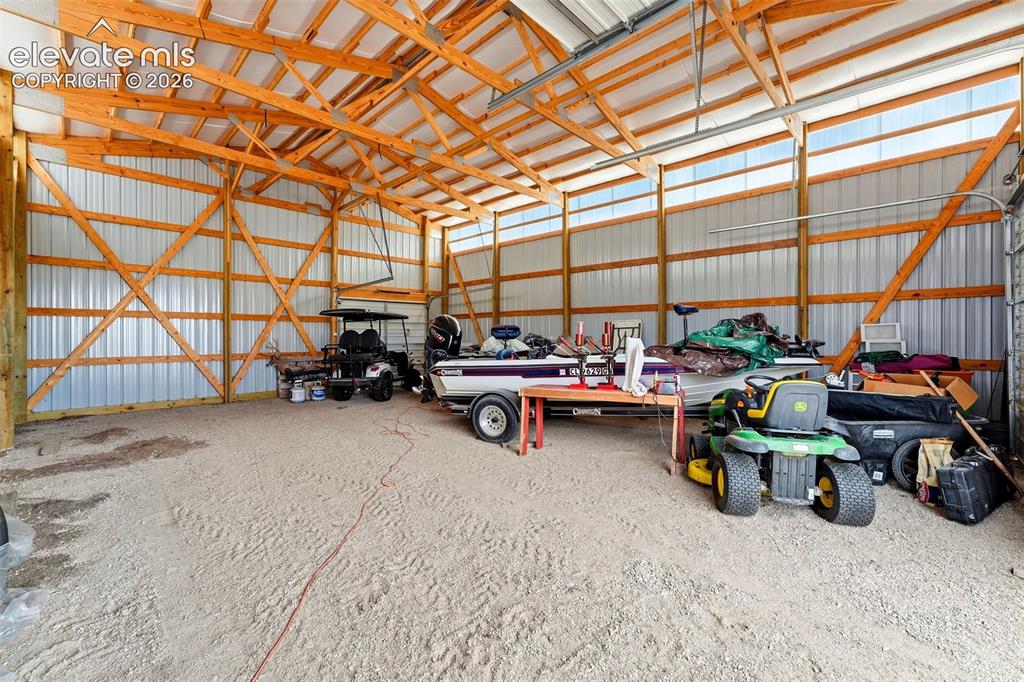 Image 42 of 50: Expansive utility building featuring a gravel floor, exposed wood framing,