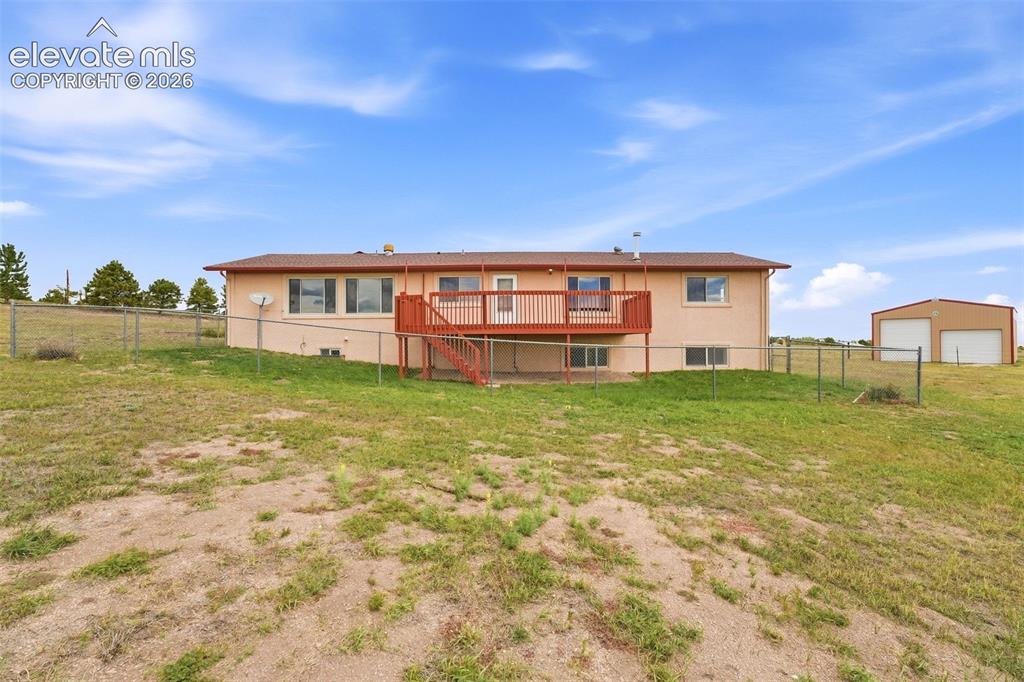 Image 44 of 50: Ranch-style exterior with a stucco finish, a raised wooden deck, a lower-le