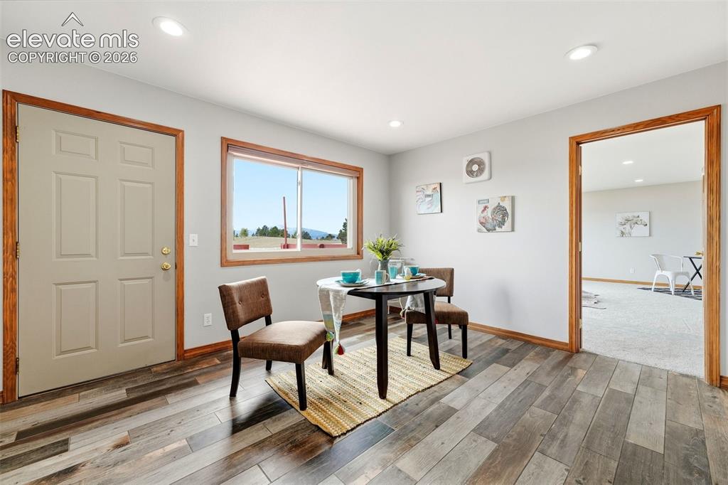 Image 8 of 50: Wood-finish flooring with natural wood trim and door frames