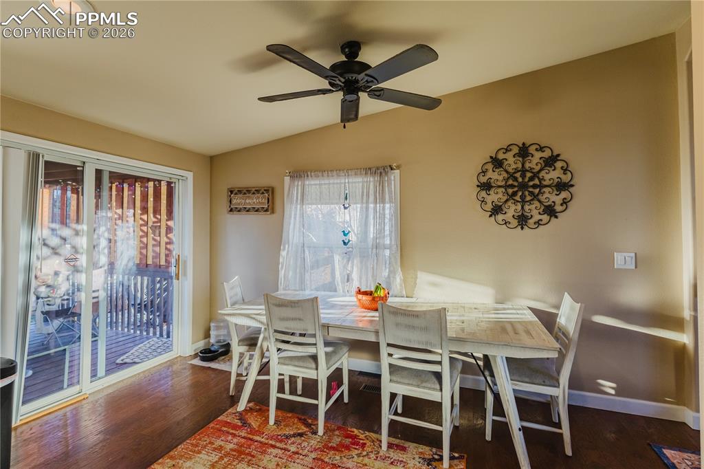 Image 15 of 30: Dining room with lofted ceiling, dark wood-style flooring, and a ceiling fa