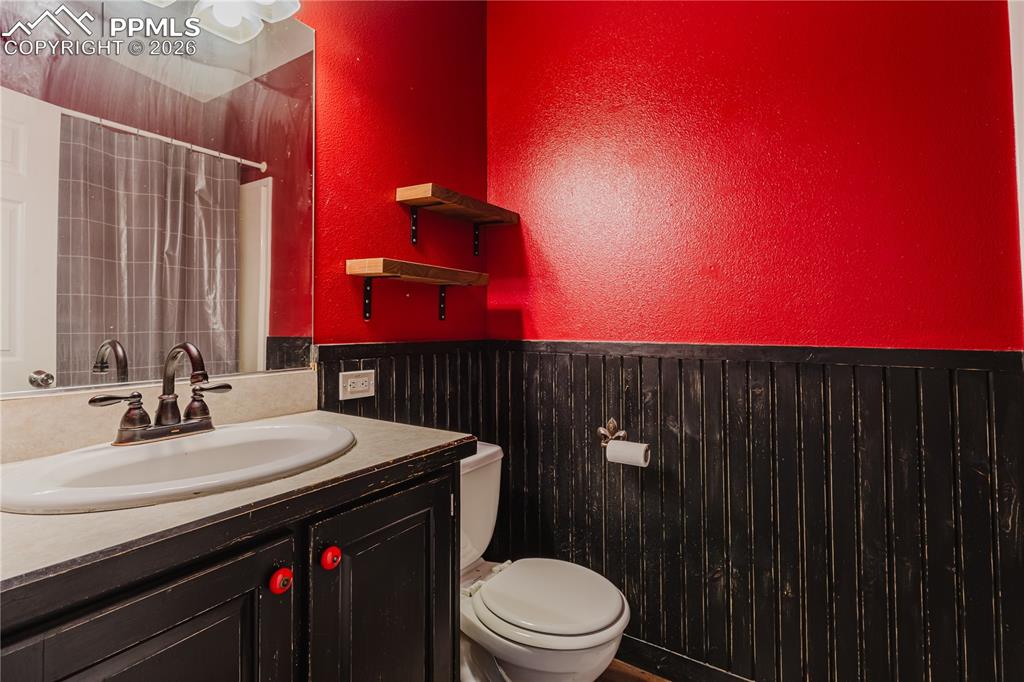 Image 16 of 30: Full bathroom featuring a textured wall, vanity, a shower with curtain, and
