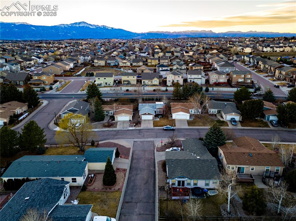 Image 27 of 30: Aerial view at dusk of a residential view and a mountain view