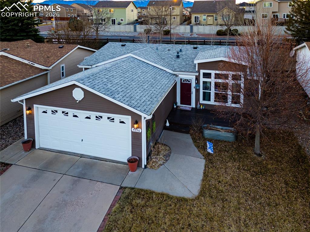 Image 29 of 30: View of front facade with a residential view, driveway, and a garage