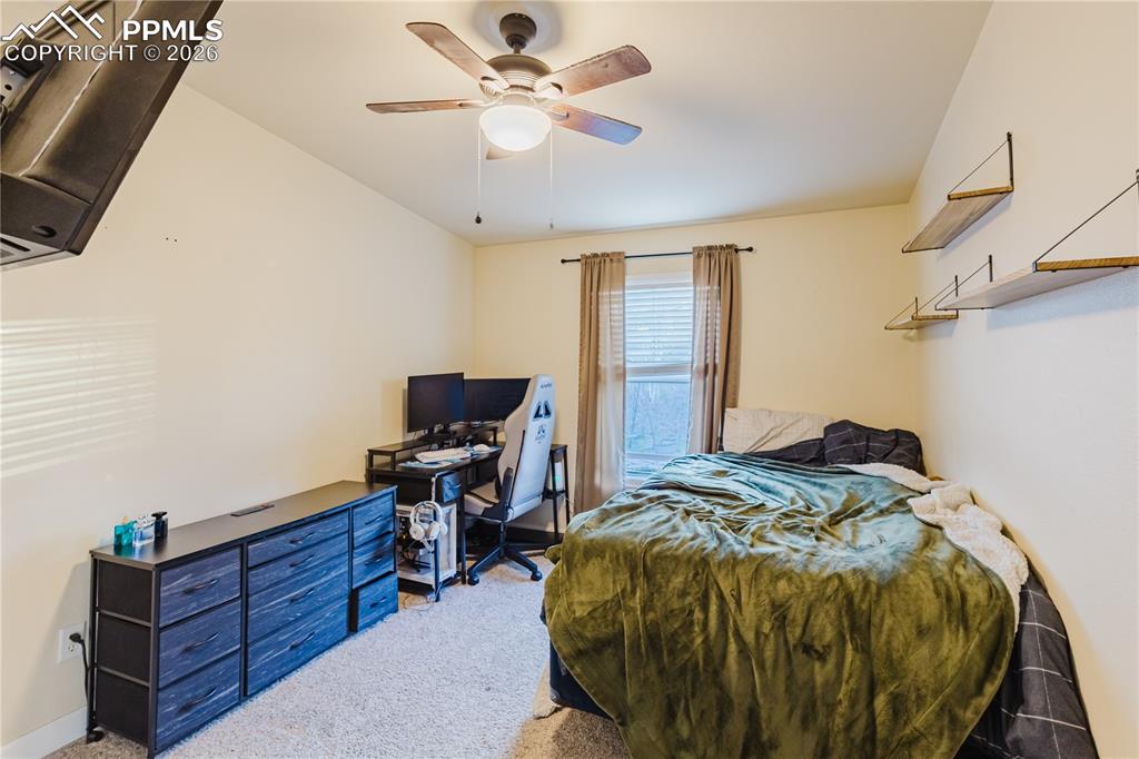 Image 6 of 30: Bedroom with carpet floors, ceiling fan, and an office area