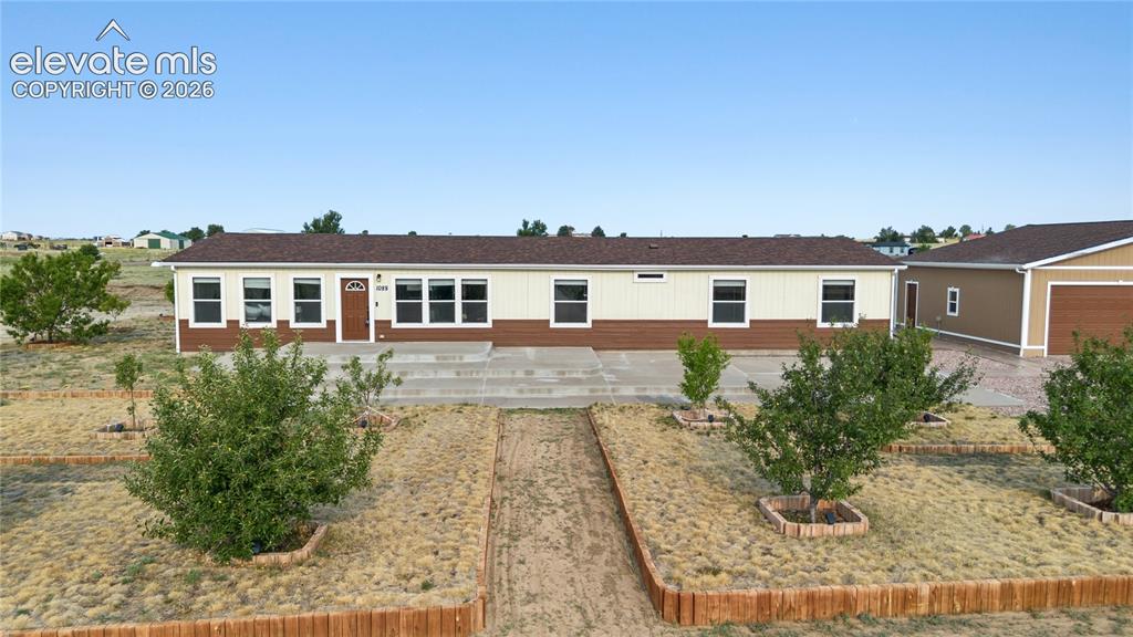 Image 1 of 49: Front of home and some of the fruit trees